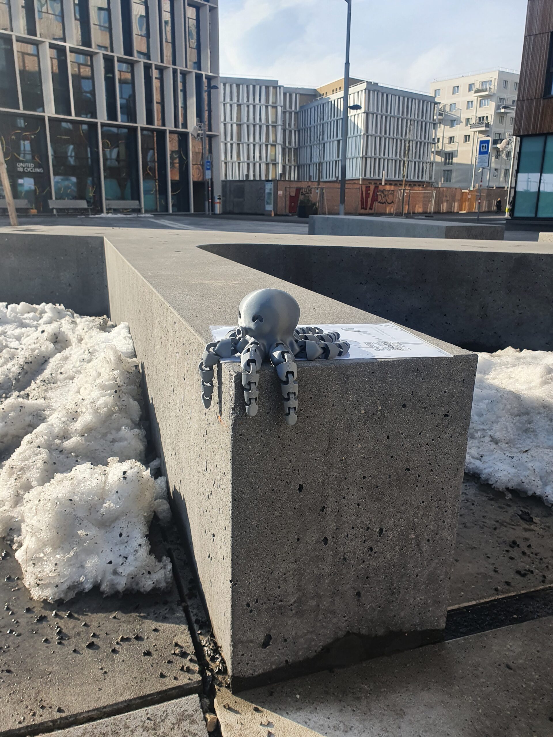 A gray 3d-printed octopus sitting inside a gray wall.