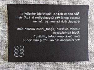 Eine schwarze Karte mit längerem Text in Spiegelschrift.